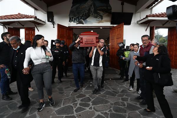 Varias personas cargan el féretro del candidato presidencial Fernando Villavicencio al termino de la misa de cuerpo presente.