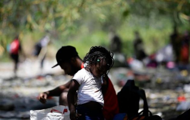 Adultos y niños migrantes descansan en la selva. Foto: EFE