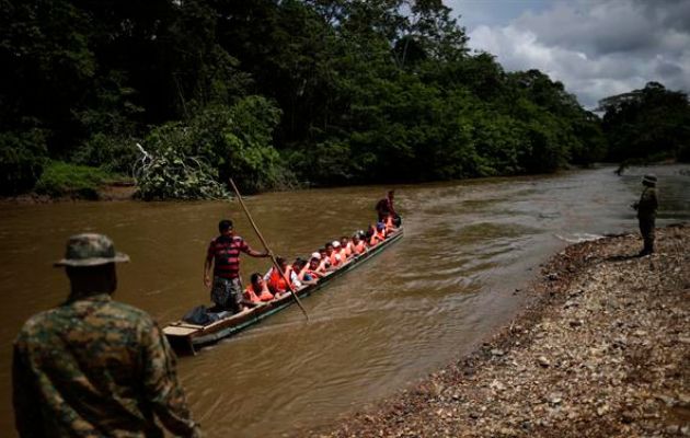 Migrantes son transportados en canoas para ser trasladados a una estación de recepción migratoria. Foto: EFE