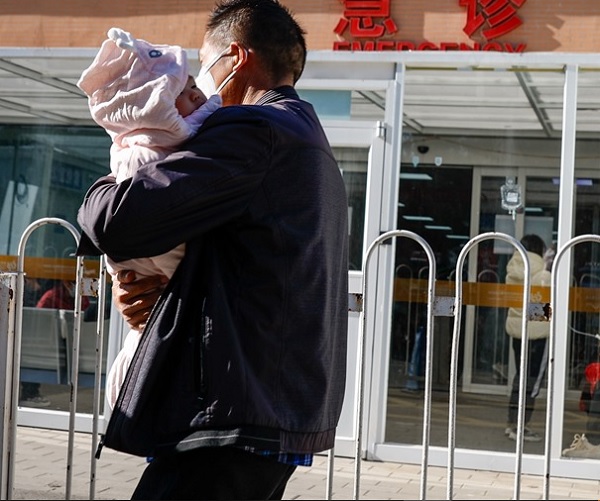 Un hombre lleva a un niño a un hospital infantil en Pekín. Foto: EFE/Mark R. Cristino
