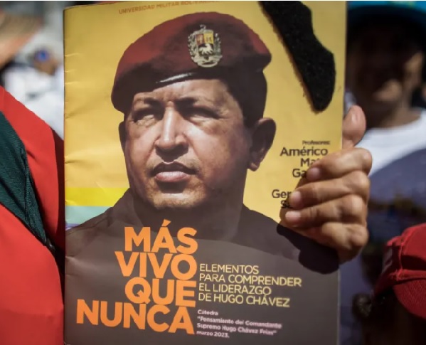Una persona sostiene un póster alusivo al fallecido presidente Hugo Chávez durante una movilización, en Caracas. Foto: EFE/Miguel Gutiérrez
