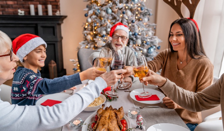 Familia feliz, brindando con vino durante una cena navideña. IMEO