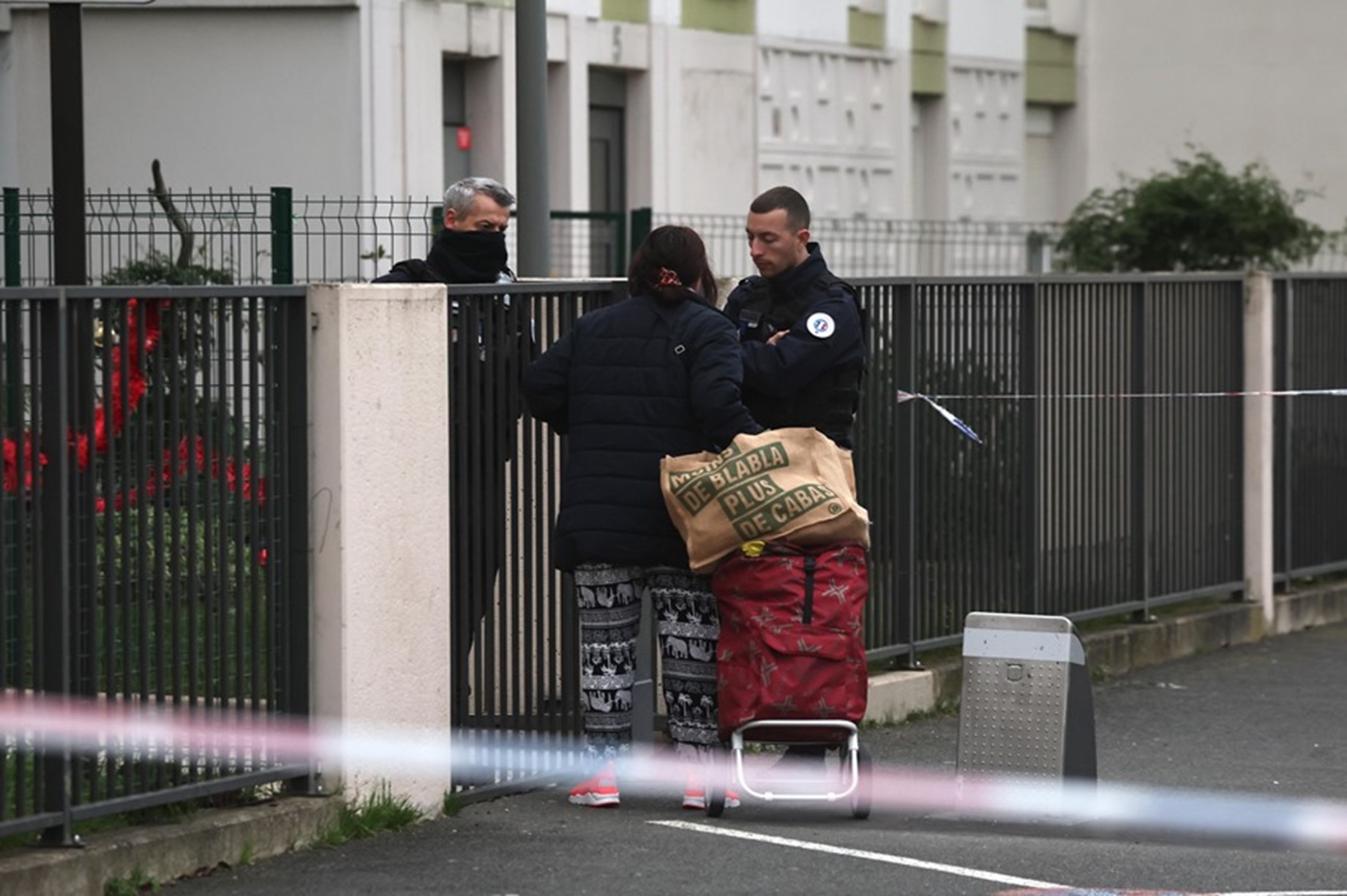 La policía pide documentación a una mujer a la entrada del edificio en el que se hallaron cinco cadáveres en Meaux, cerca de París. Foto: EFE