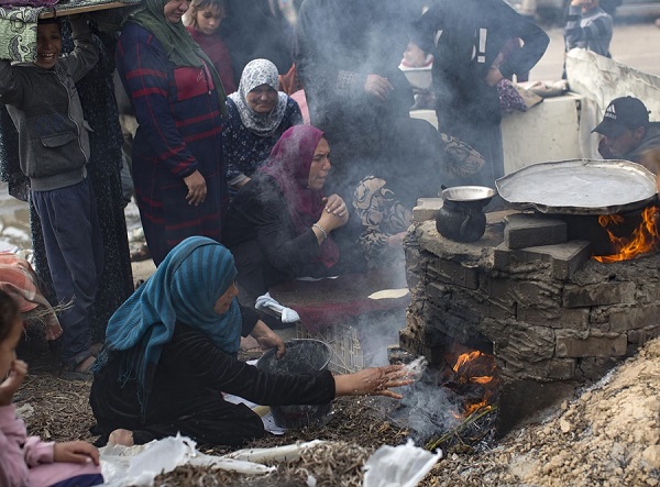 Palestinos desplazados internos preparan pan con leña ante la escasez de gas en los campos de refugiados de la ciudad de Rafah. Foto: EFE