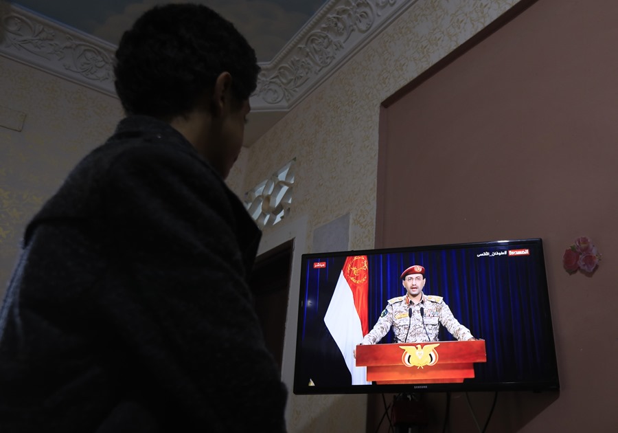 Una persona ve una declaración televisiva del portavoz militar de los hutíes, Yahya Sarea, tras los ataques aéreos de EE.UU. y Reino Unido. Foto: EFE