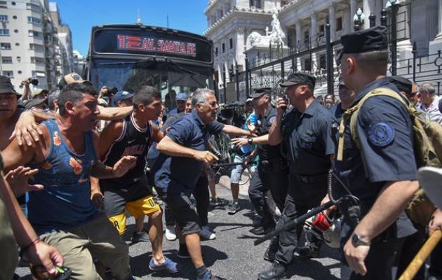 Manifestantes se enfrentan a la policía durante una protesta convocada por la Confederación General del Trabajo. Foto: EFE