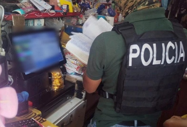 Policía revisa el material encontrado en un comercio, donde se detuvo a un comerciante relacionado con este hecho. Foto: Cortesía Policía Nacional