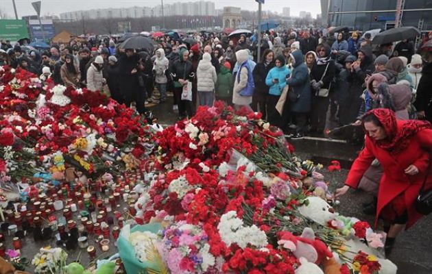 La gente llora y lleva flores en la sala de conciertos Crocus City Hall tras un ataque terrorista en Krasnogorsk. Foto: EFE