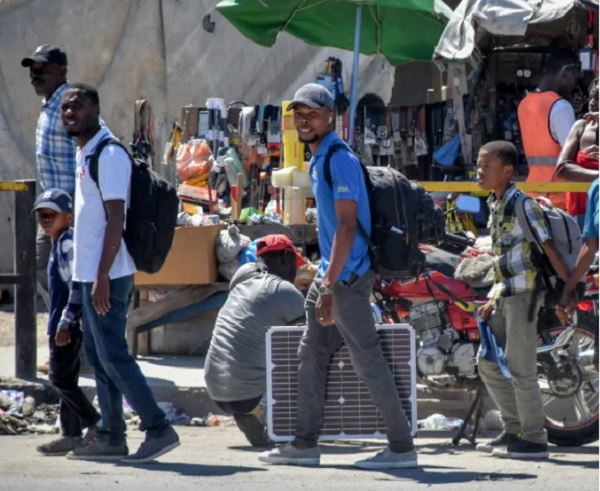 Personas caminan por una vía con sus pertenencias en Puerto Príncipe (Haití). Foto: EFE/Siffroy Clarens