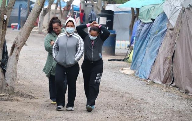 Mujeres migrantes caminan por un campamento ubicado a orillas del río Bravo en Matamoros, estado de Tamaulipas. Foto: EFE