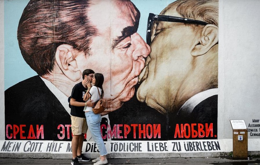 Dos turistas se besan frente al mural 'My God, Help Me to Survive This Deadly Love', también conocido como 'Beso fraternal', del artista ruso Dmitri Vrúbel. Foto: EFE