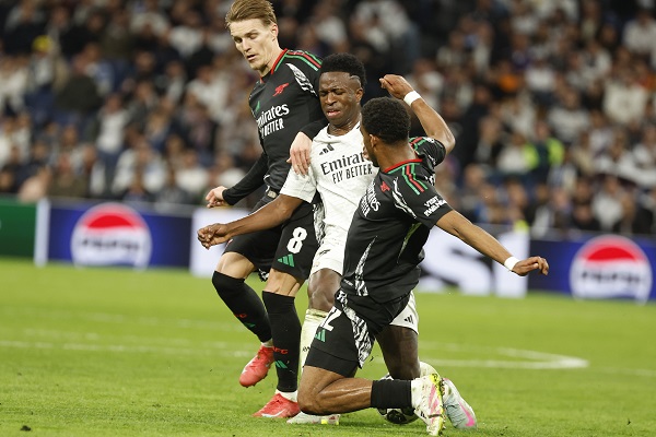 El brasileño del Real Madrid, Vinicius (cent.), disputa el balón ante los jugadores del Arsenal, Martín Odegaard (izq) y Jurrien Maduro, Foto: EFE