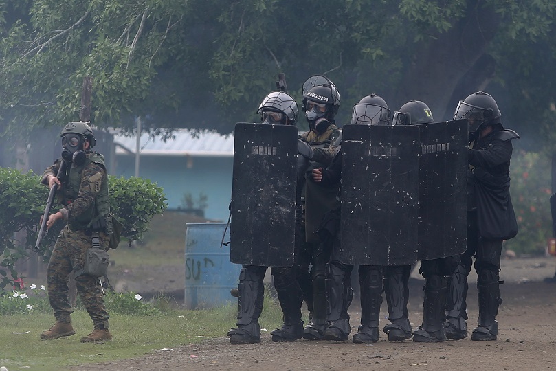 Integrantes de la unidad antidisturbios durante un enfrentamiento en Arimae, provincia de Darién. Foto: EFE