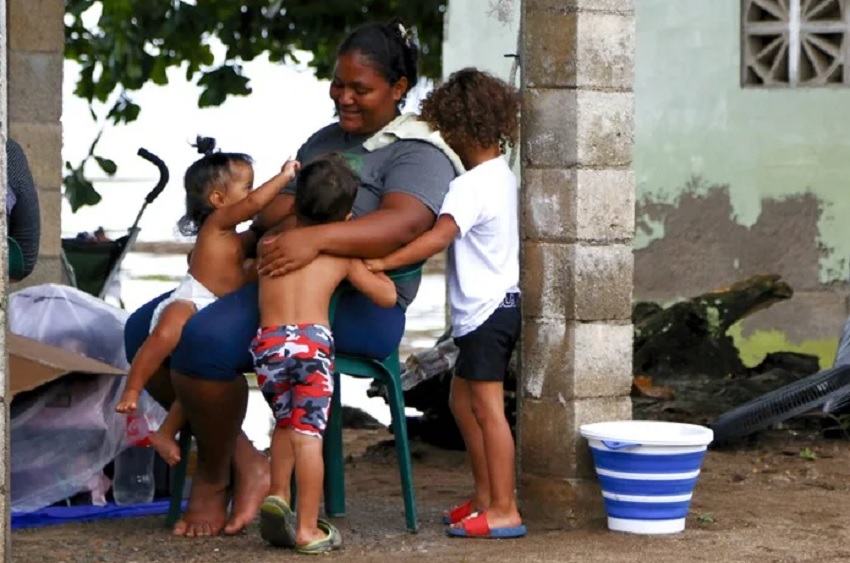 La venezolana Marielbis Eloina Campos, de 33 años, jugando con sus hijos, en el pueblo pesquero de Miramar en el Caribe panameño. EFE/ Moncho Torres