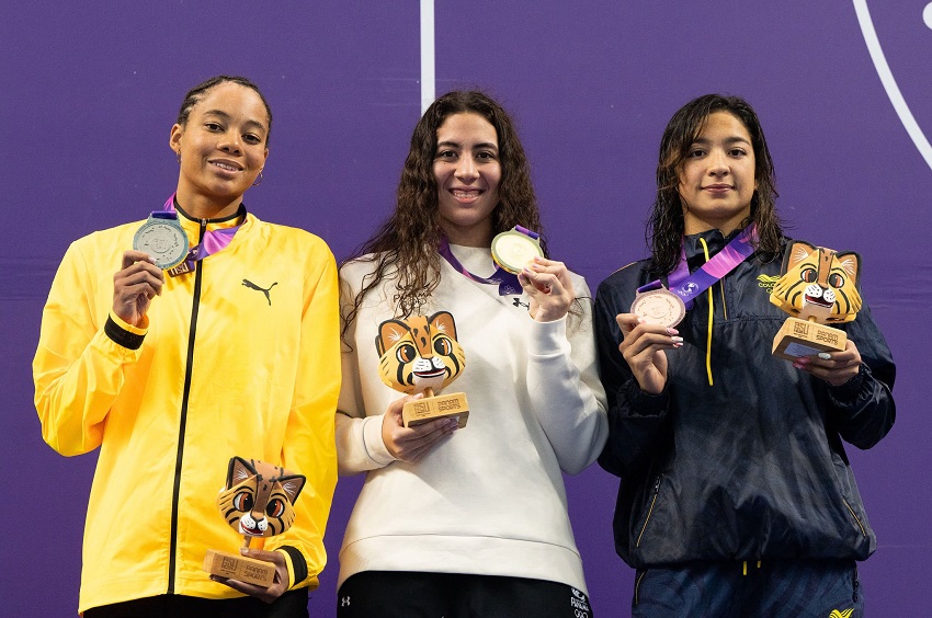 Emily (centro) con su medalla de oro de los 100 metros pecho. Foto: Cortesía COP