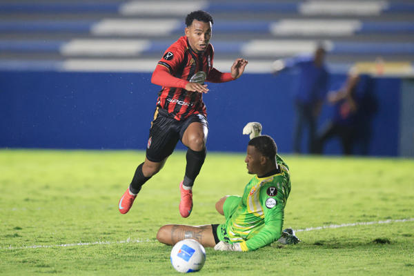 Yair Jaén, de Sporting, disputa el balón con el portero Anthony Walker, de Herediano. Foto: EFE