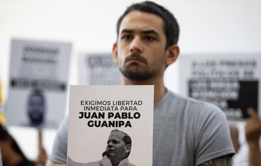 Ramón Guanipa sostiene un cartel de su padre detenido, Pedro Guanipa. Foto: EFE