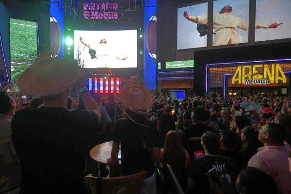Personas observan la transmisión del espectáculo del cantante Bad Bunny en el Super Bowl de Estados Unidos este domingo, en San Juan. Foto:EFE