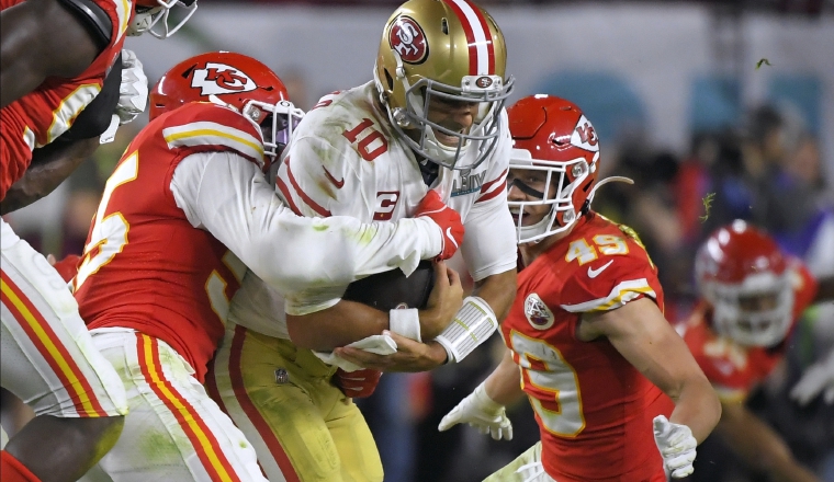 4.   Frank Clark (izq.) atrapa a Jimmy Garoppolo del San Francisco. 