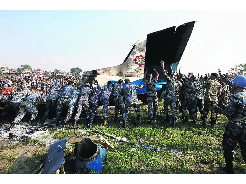 Militares nepalíes mueven la aeronave accidentada.(AP)