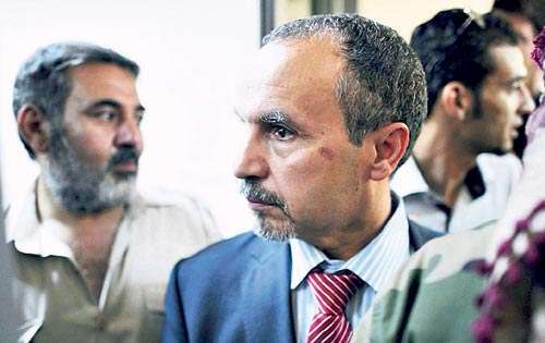 <p>El ministro de Sanidad rebelde, Naji Barakat (c), llega a la antigua sede del Ministerio de Petróleo en Trípoli.</p>