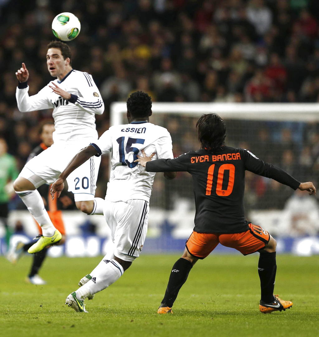 El delantero argentino del Real Madrid, Gonzalo Higuaín (i), cabecea un balón ante su compañero, el ghanés Michael Essien (c). EFe<br>