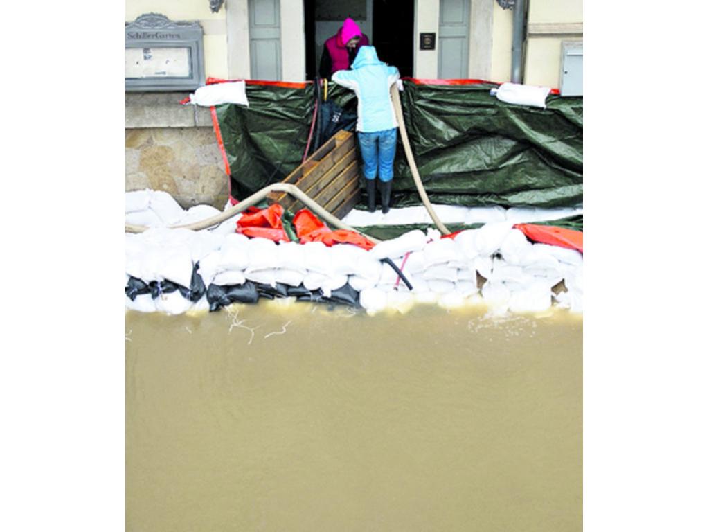 6- Una caseta de jardín parcialmente sumergida en el agua tras las inundaciones. (Fotos AP y EFE)