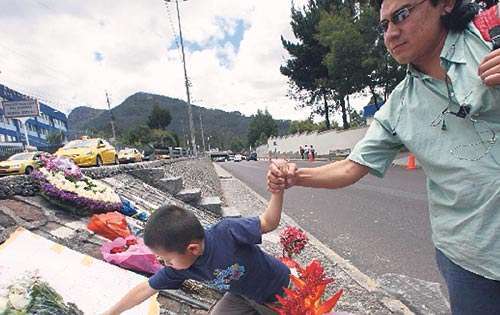 <p>Tristeza. Un niño y su padre colocan una ofrenda cerca del Hospital militar.</p>