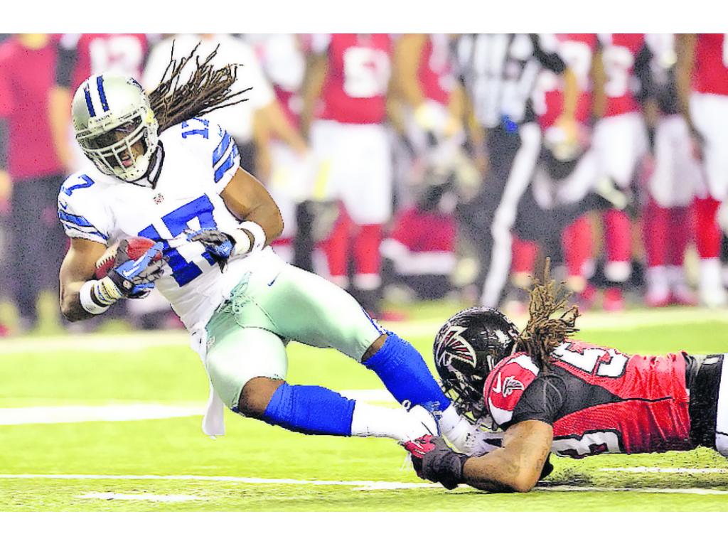 Defensa. Peterson (d) evita el avance de Harris, de Dallas.(AP )