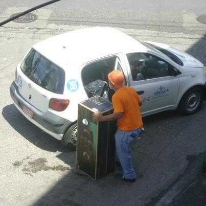 Una persona mete dentro de un vehículo propiedad del Ministerio de Educación uno de los artículos robados. <br>