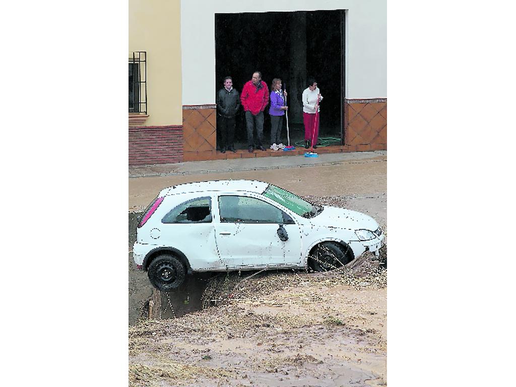 Un auto es arrastrado por la corriente de agua. (AP)