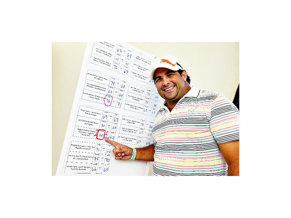 Carlos Fernández señala el tablero con los resultados finales de la competición de este año. Fernández fue parte del equipo que logró conquistar el primer premio gross el sábado.()