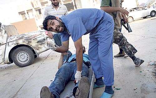 <p>Un médico presta auxilio a un rebelde herido.</p>
