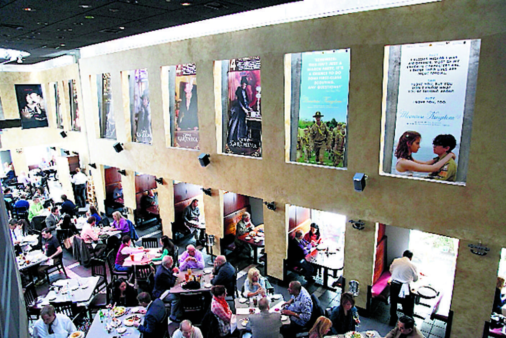 Esta instantánea muestra a diversas personas almorzando debajo de posters de producciones cinematográficas. El restaurante Kate Mantilini está ubicado en Beverly Hills, California.