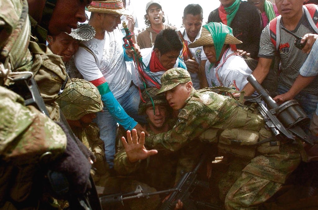 Dolor. Un soldado protege a otro de una golpiza.(EFE)
