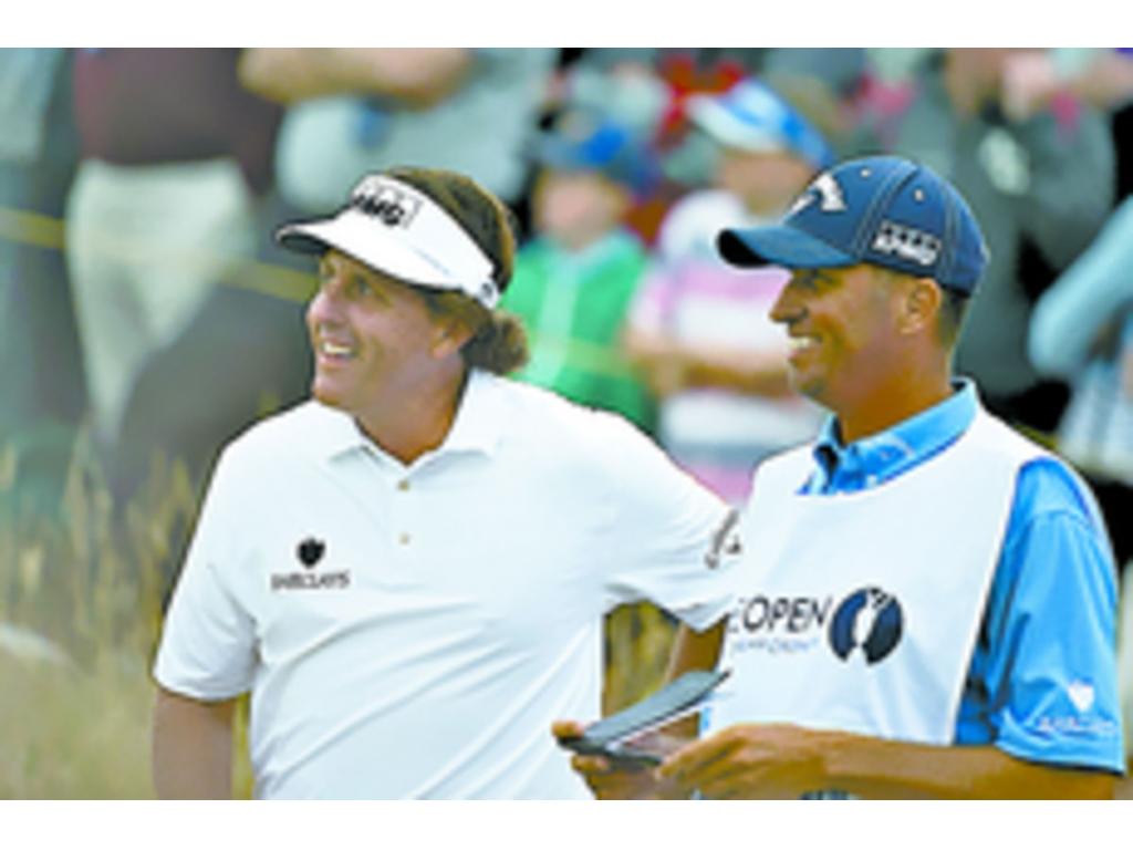 Mickelson conversa amigablemente con su caddie en un torneo.(AP )
