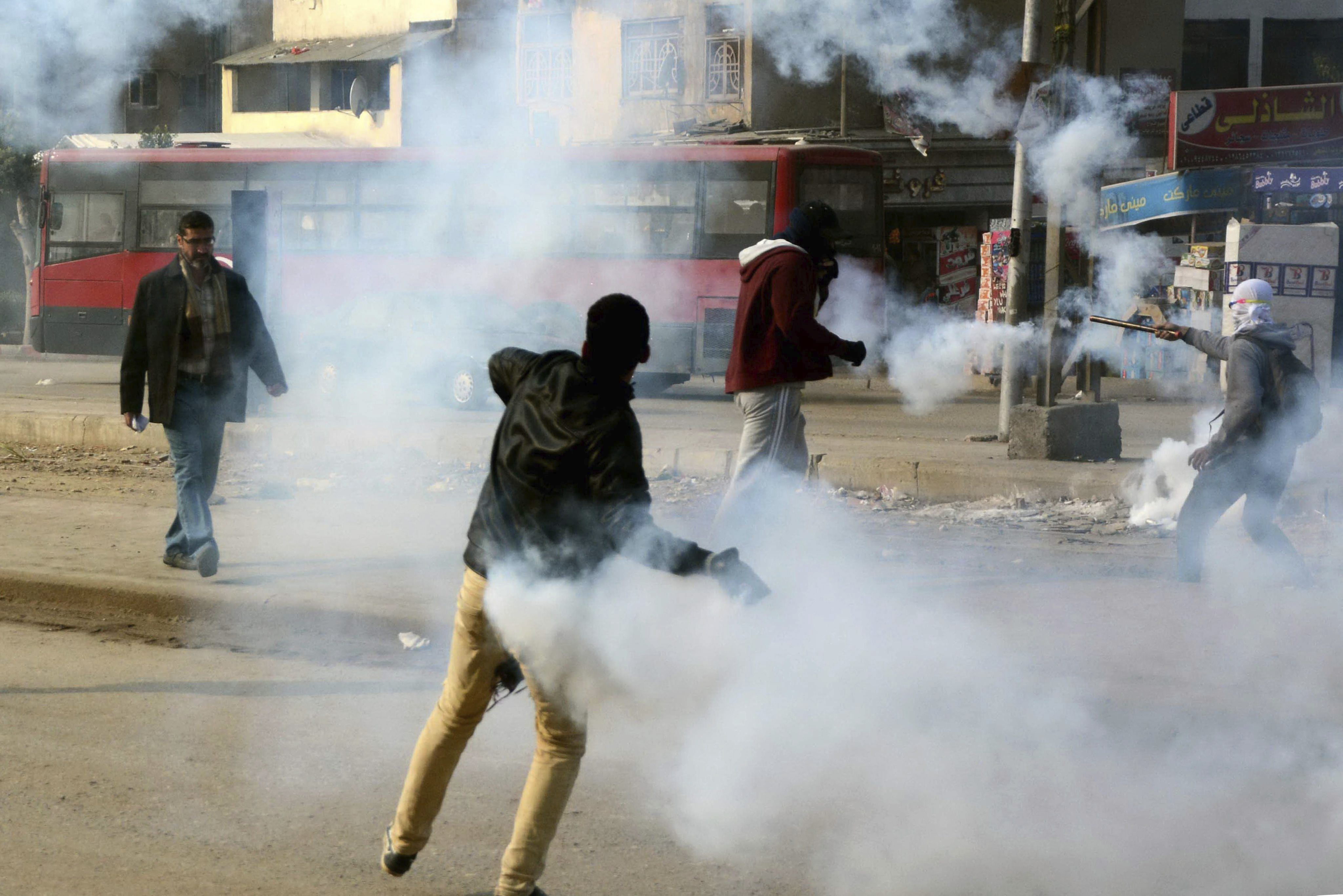 Varios simpatizantes de Los Hermanos Musulmanes lanzan de vuelta el gas lacrimógeno lanzado por la Policía antidisturbios durante una protesta en El Cairo
