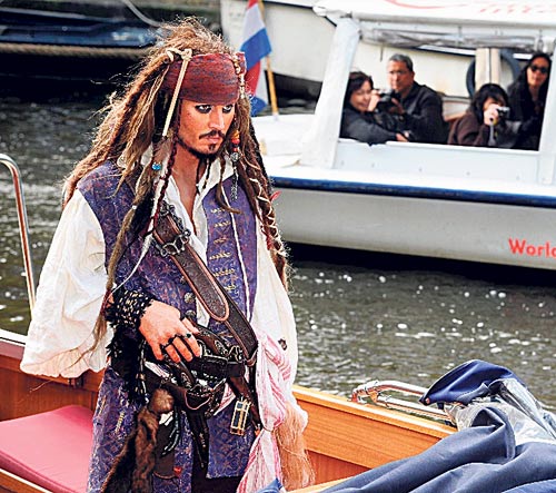 <p>Turismo. Figura del capitán Jack en la riviera francesa es admirada por unos turistas.</p>