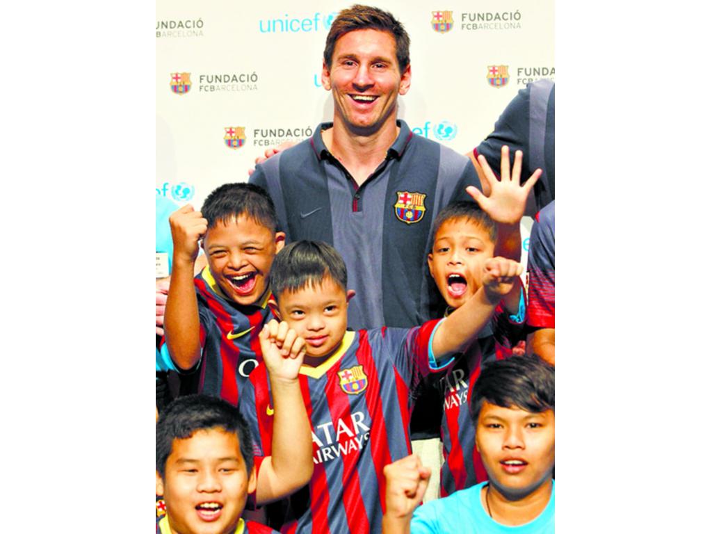 El jugador argentino posa con niños durante un evento en Tailandia. (EFE)