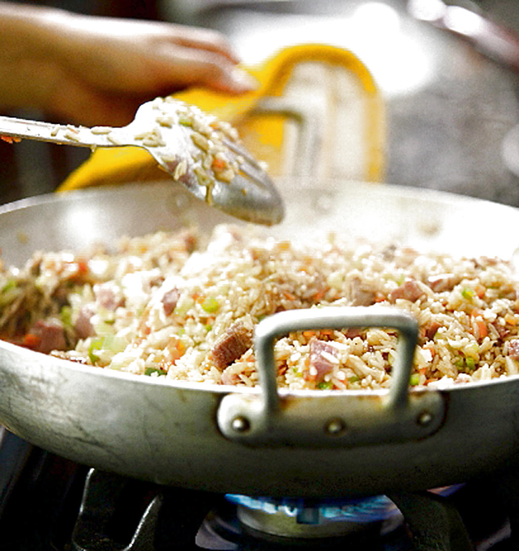 Agregue el arroz y agua. Déjelo hervir. Revuelva todo bien y reduzca el fuego hasta que el arroz esté seco y blando. ()