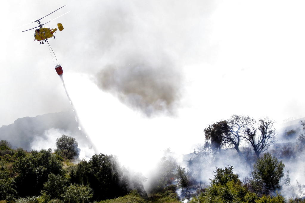 Un helicóptero echa agua sobre el incendio declarado en Adanaia, Alhandra, Portugal. Foto EFE<br>