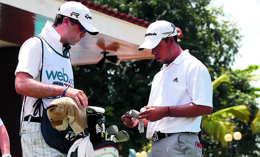 Miguel, mientras conversa con su caddie en el Panamá Claro Championship 2013.(Anayansi Gamez)