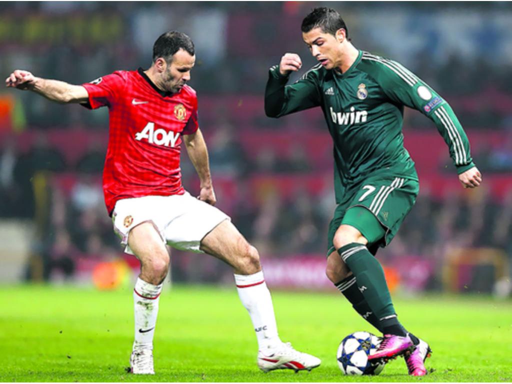 Cristiano Ronaldo controla el balón ante la mirada de su excompañero, el galés Ryan Giggs, en el partido de vuelta de los octavos de final.(EFE)