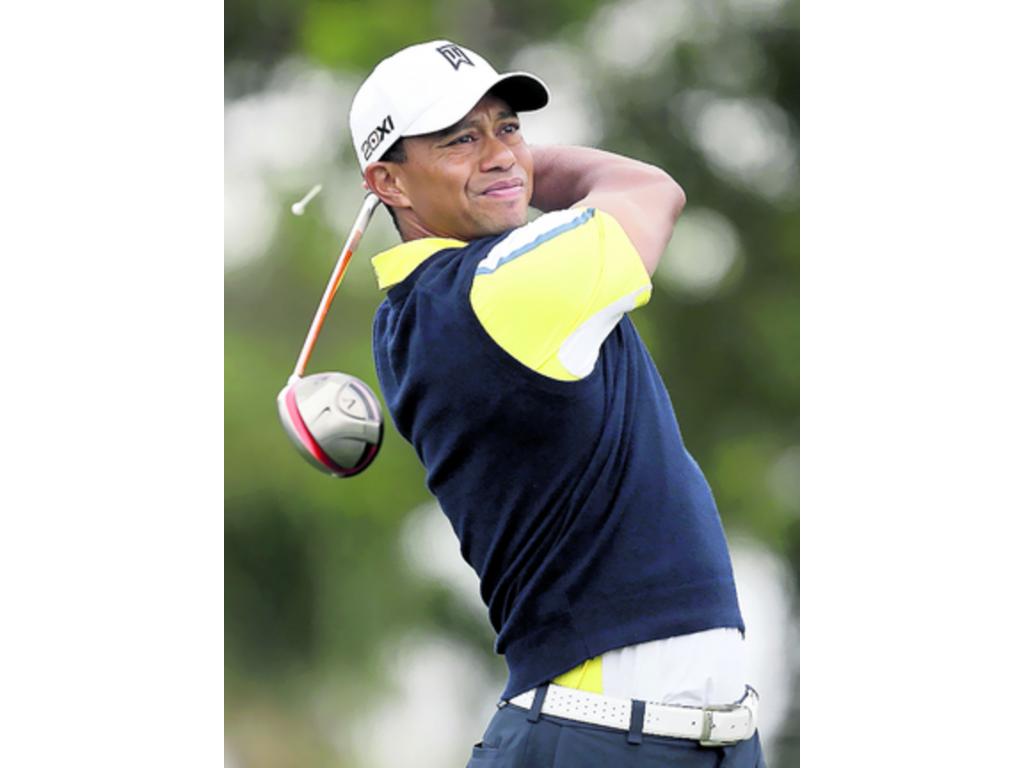 Woods intenta salir de una trampa de arena en la ronda de ayer.(AP)