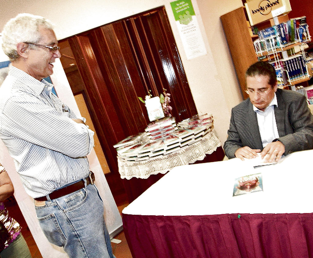Presentación. El autor autografía una de sus obras.()