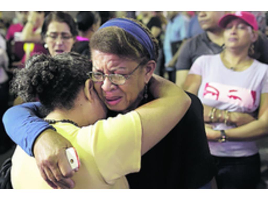 Un grupo de personas se abrazan y consuelan en las calles de Caracas, al conocer la trágica noticia. La ciudadanía aún no puede creer que su líder ha dejado de existir y que tienen que prepararse para despedirlo el viernes.