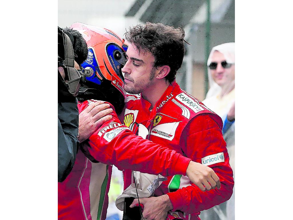 Apoyo. Alonso (dcha.) abraza a su compañero Felipe Massa. (EFE)