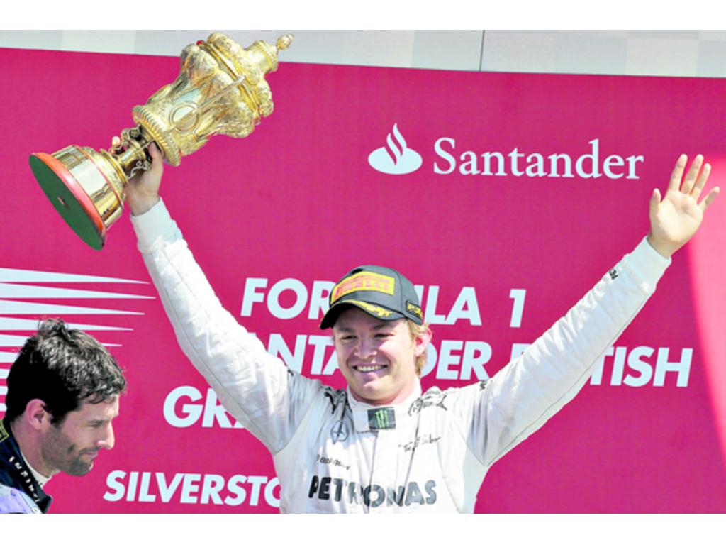 El piloto alemán Nico Rosberg baña con champaña a su homólogo español Fernando Alonso en el podio de premiaciones del famoso circuito británico de Silverstone.(AP y EFE)