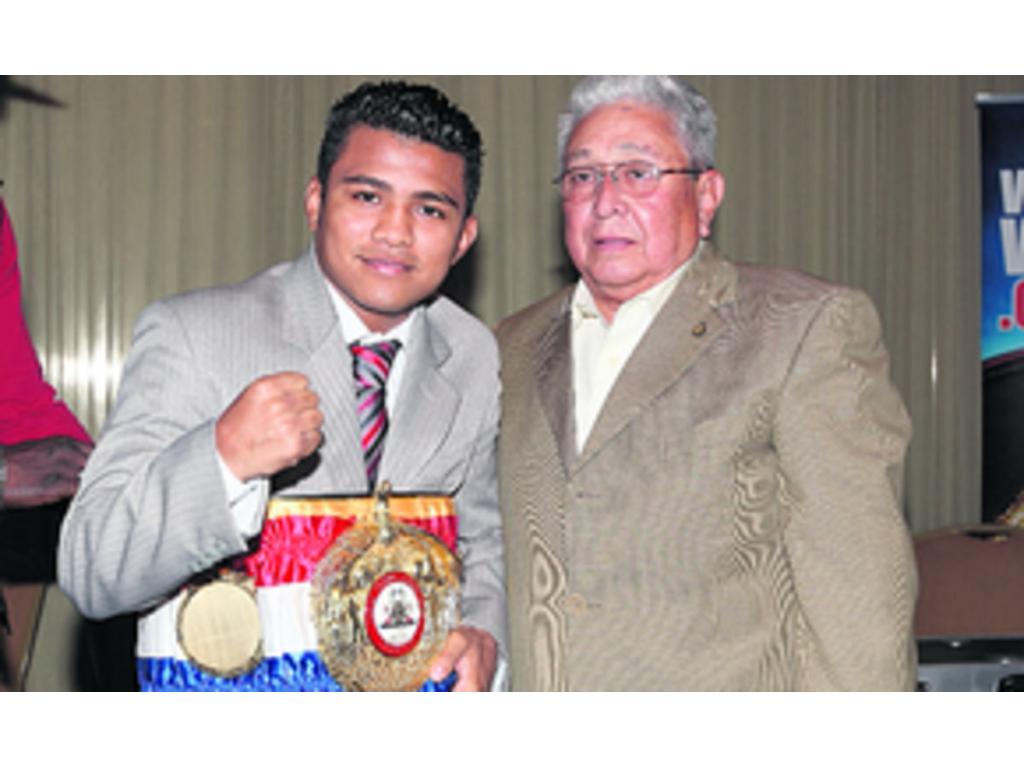 González (izq.) luce su cinturón de supercampeón minimosca, en compañía de Fiengo.(Anayansi Gamez)