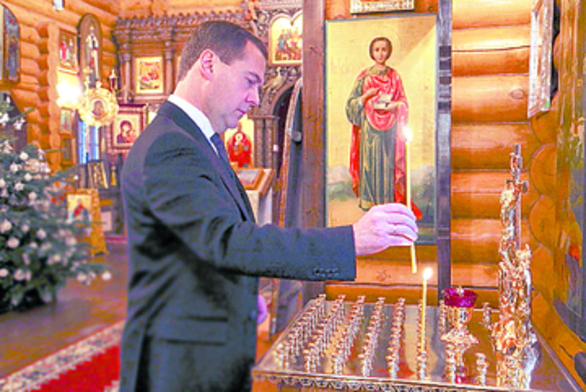 El primer ministro ruso, Dmitry Medvedev, enciende una vela.(EFE)